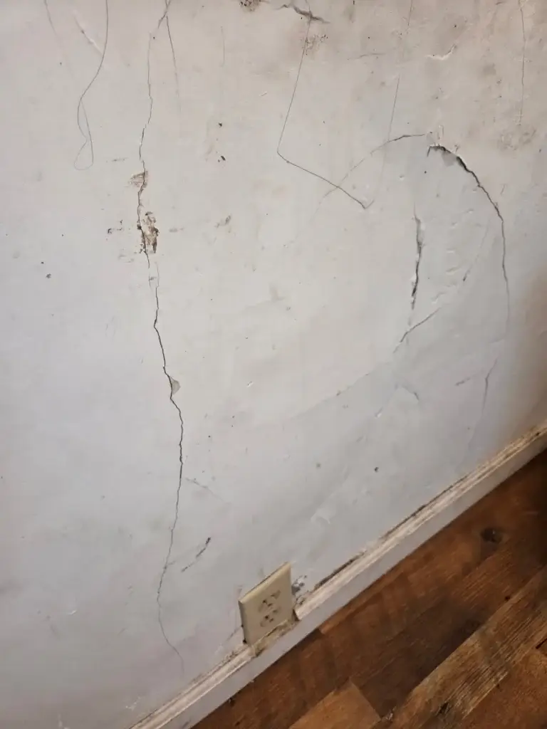 Cracked plaster wall before repair