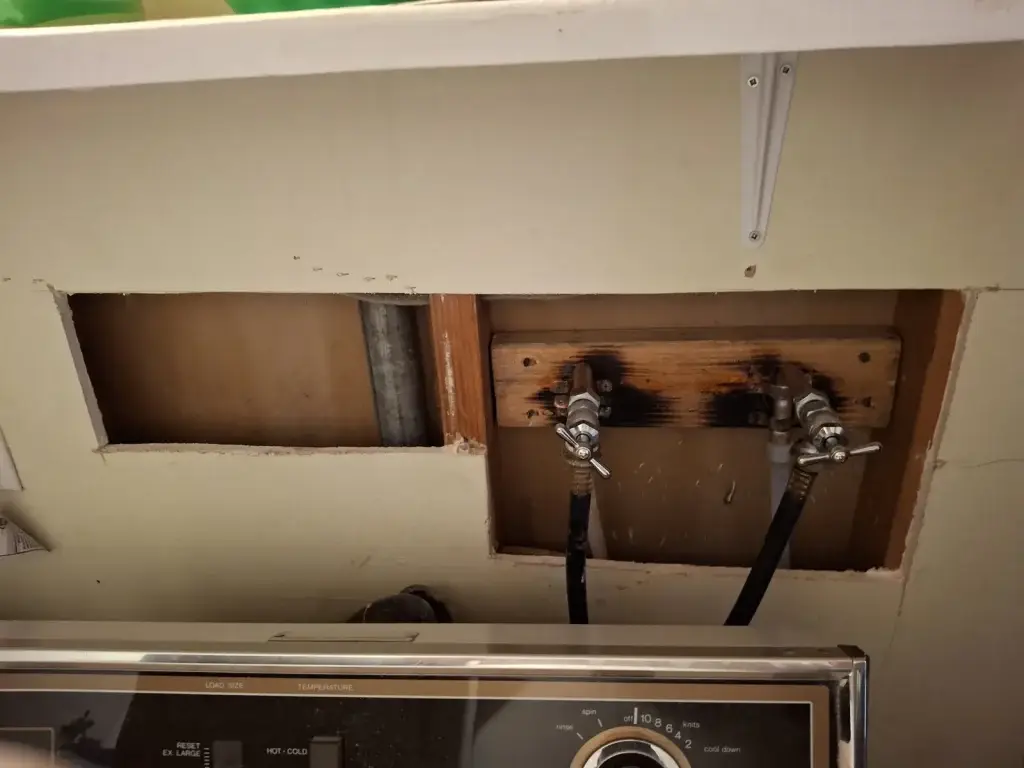 Opened laundry wall at washer hookups
